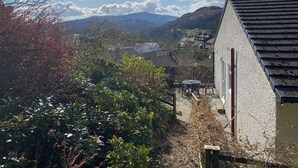 Un quartier résidentiel avec des maisons, un jardin et une vue sur les montagnes.