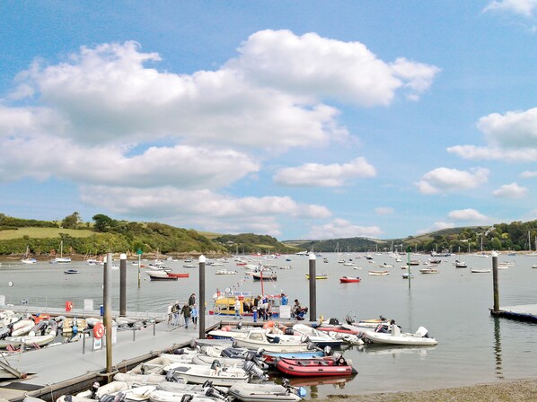 A marina with various boats docked, a pier, and a grassy hill in the background. - 1 bedroom accommodation in Fore St (Fore St)