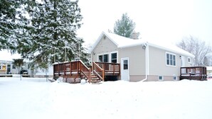A two-story house with a wooden deck and a covered porch.