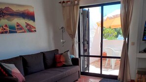 Ein Wohnzimmer mit Sofa, Teppich, Stuhl und Tisch.