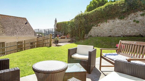 A patio area with wicker furniture and a small round table. - 5 bedroom accommodation in Devon Rd 2 (Devon Rd 2)