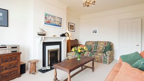 A living room with a fireplace, a sofa, a coffee table, and a chandelier. - 1 bedroom accommodation in Mount Boone (Mount Boone)