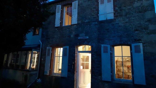 Ein zweistöckiges Gebäude mit Fensterläden und einer sichtbaren Tür.