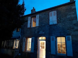A two-story building with shuttered windows and a visible door.