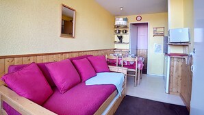 Ein gemütliches Zimmer mit einer Holzbank, einem kleinen Tisch und einem Fernseher.