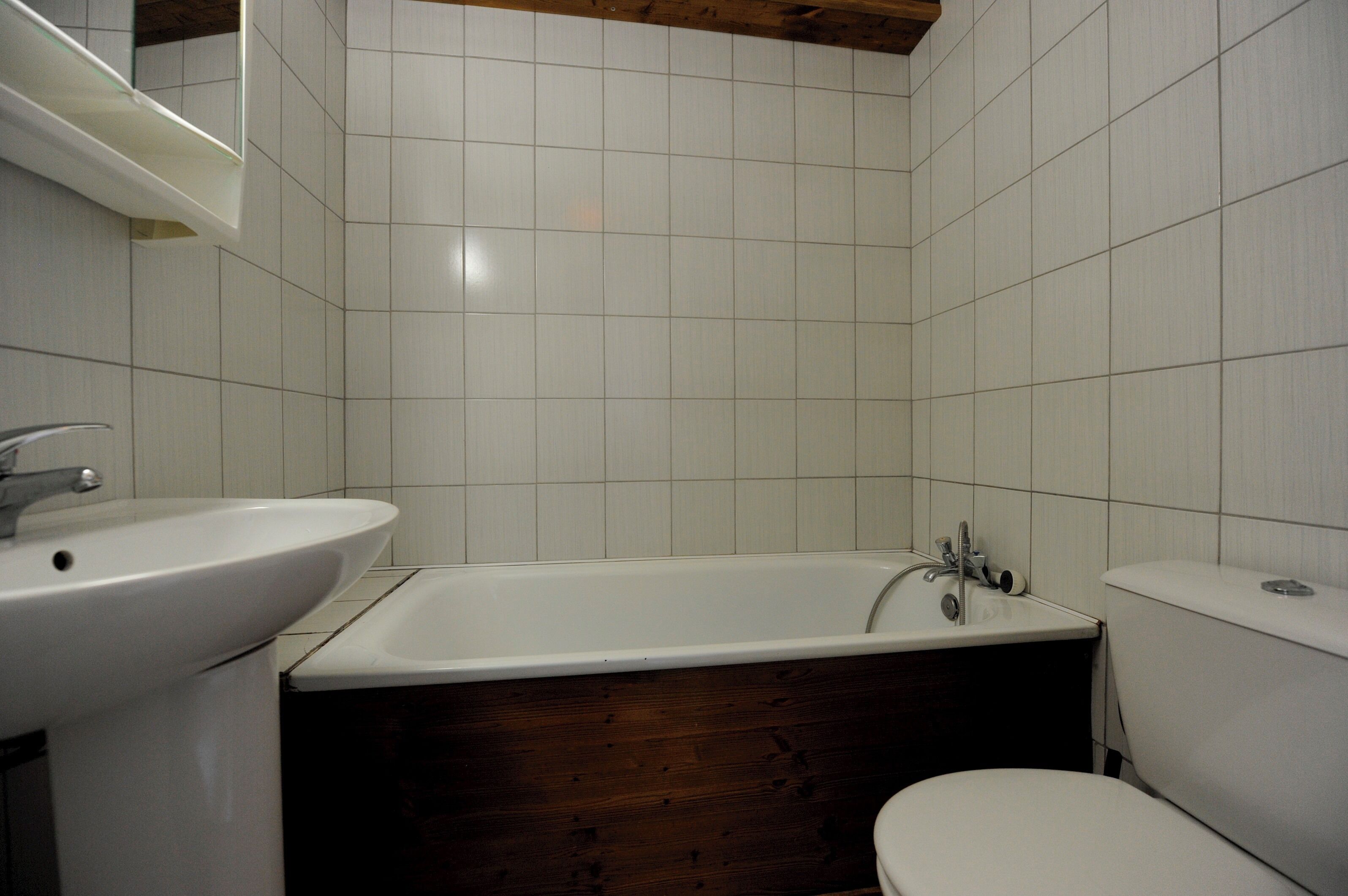 A bathroom with a white sink, a bathtub, and a toilet.