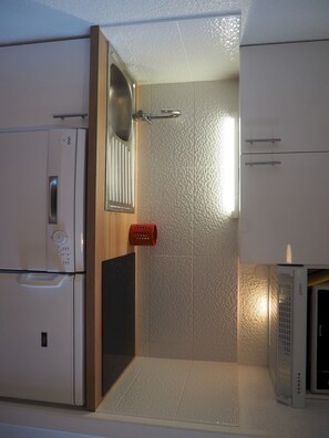 A compact kitchen with a microwave, a sink, and a small refrigerator.