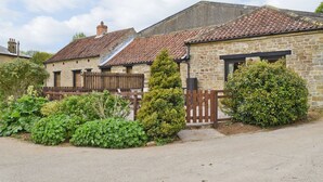 A stone building with a tiled roof, a wooden fence, and a well-maintained garden. - 1 bedroom accommodation in High Yedmandale near West Ayton (High Yedmandale near West Ayton)