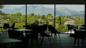 A dining area with tables and chairs facing a scenic view of mountains and greenery. - Syncrosfera Fitness & Spa Health Hotel Boutique (Pedreguer)