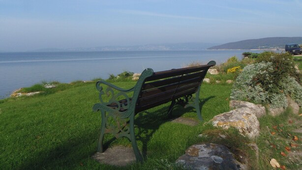 A bench overlooking a body of water with a distant view of a city skyline. - 3 bedroom accommodation in Silverdale near Grange Over Sands (Silverdale near Grange Over Sands)