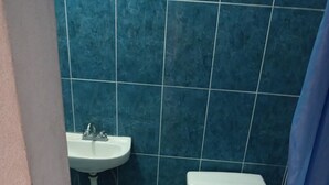 A bathroom with a toilet, sink, and tiled floor. - Room-lodging and Camping the Island (Tlaquiltenango)