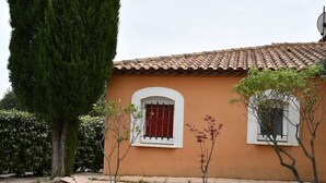 A building with a tiled roof, two windows with white frames, and a small tree in front. - Independent 25m2 studio in Villa: Wi-fi + terrace (Saint-Gély-du-Fesc)
