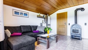 Un salon avec un canapé, une table basse, une cheminée et une porte.
