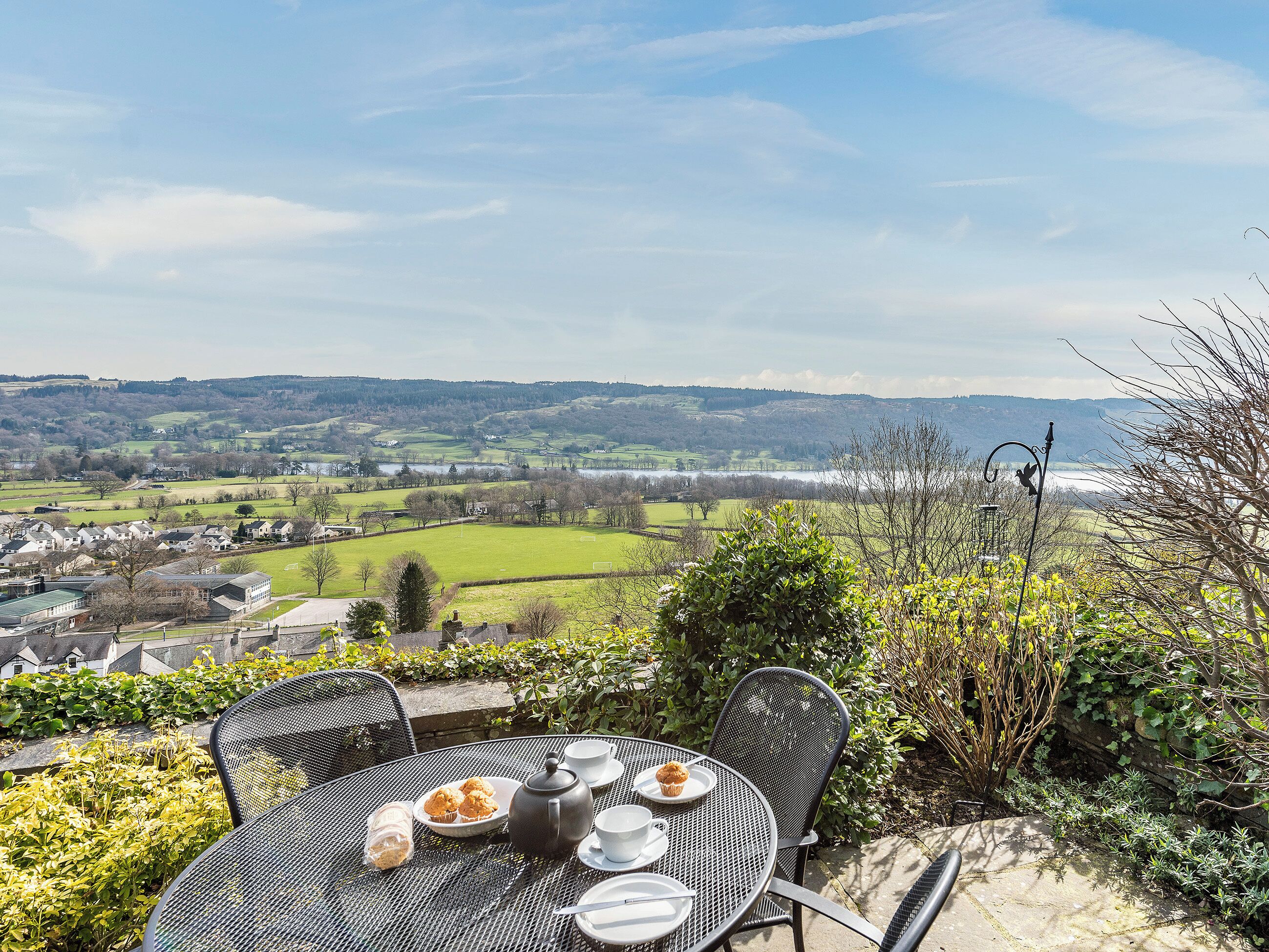 A table with a view of a rural landscape, including fields and a distant body of water.