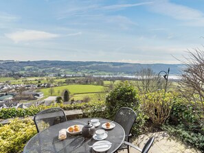 A table with a view of a rural landscape, including fields and a distant body of water. - 2 bedroom accommodation in Coniston (Coniston)