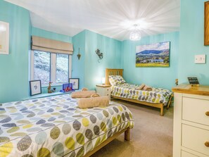 A room with two beds, a window with a view of trees, a painting of a landscape, and a sign indicating WiFi password. - 2 bedroom accommodation in Coniston (Coniston)