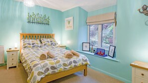 A bedroom with a bed, bedside tables, a window with a view, and a chandelier. - 2 bedroom accommodation in Coniston (Coniston)