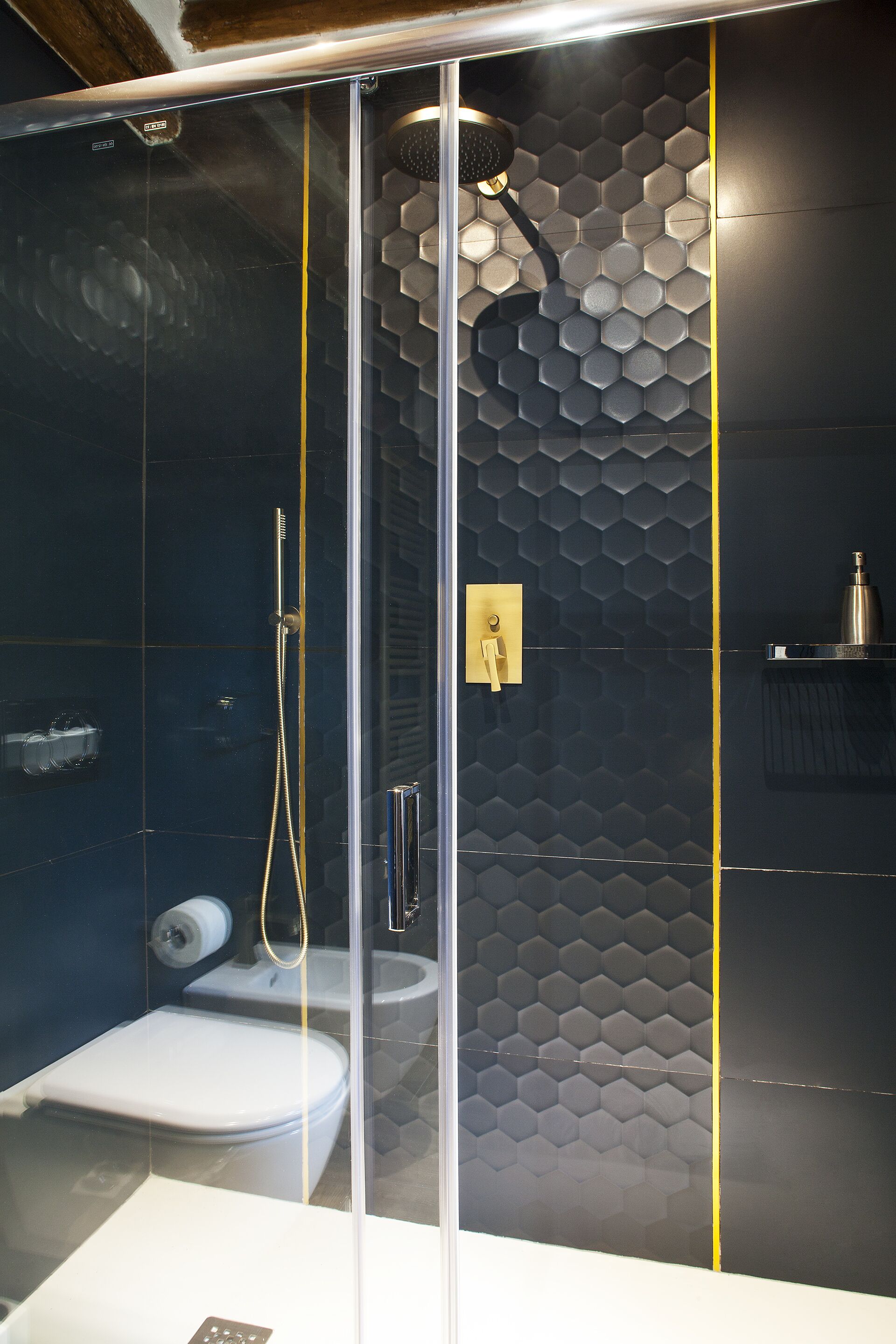 Un bagno moderno con cabina doccia in vetro, un water e un lavandino.