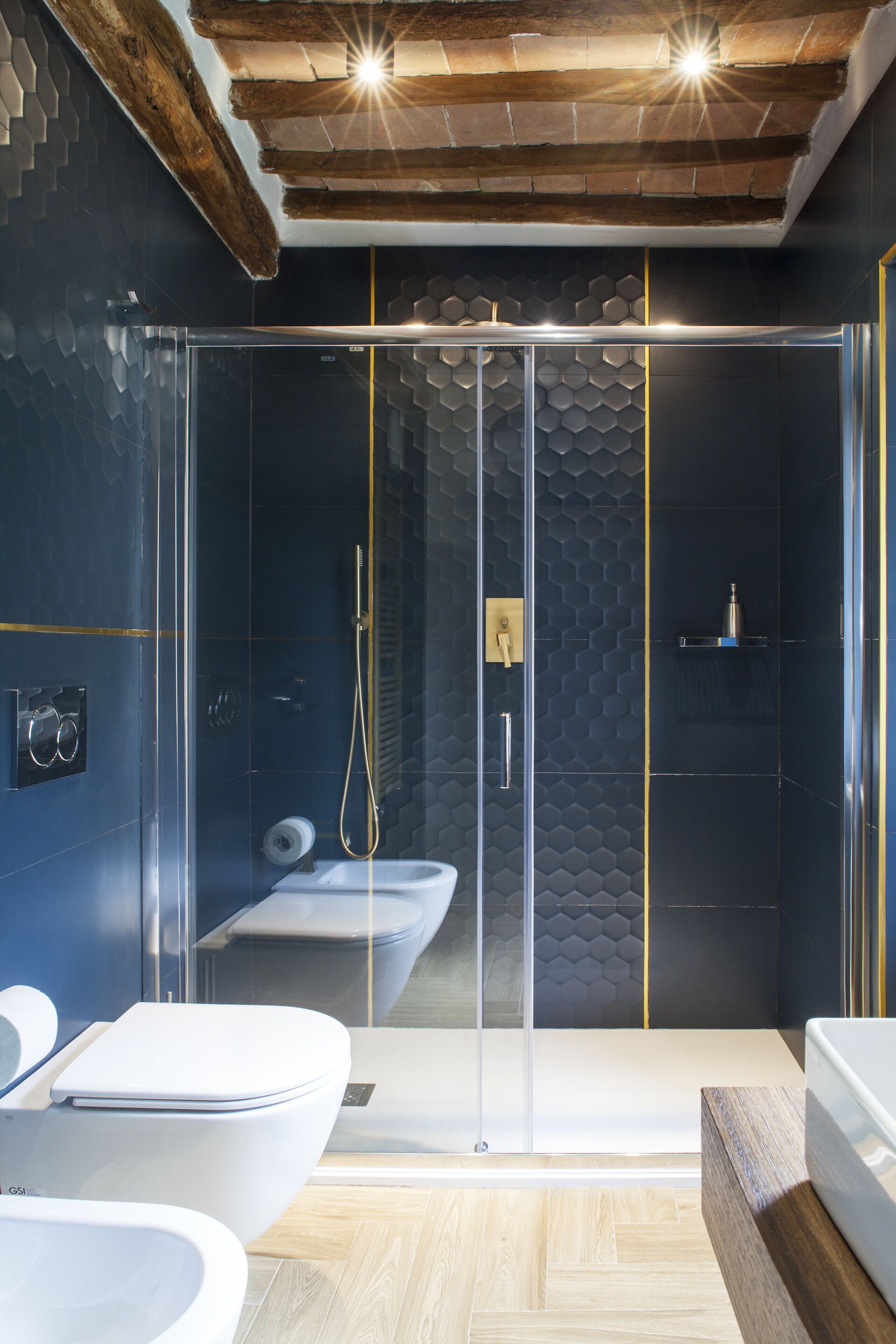 A modern bathroom with a glass-enclosed shower, a white toilet, and a wooden vanity.