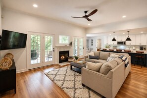 A spacious living room with a fireplace, a large sofa, and a television.