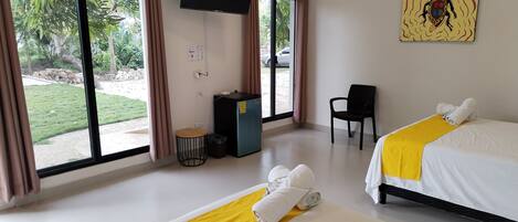 Een hotelkamer met twee bedden, een televisie, een bureau en een stoel.