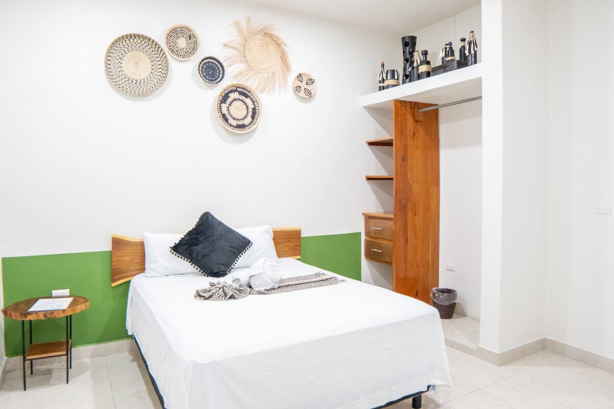 A neatly arranged bedroom with a bed, bedside table, and a wardrobe.