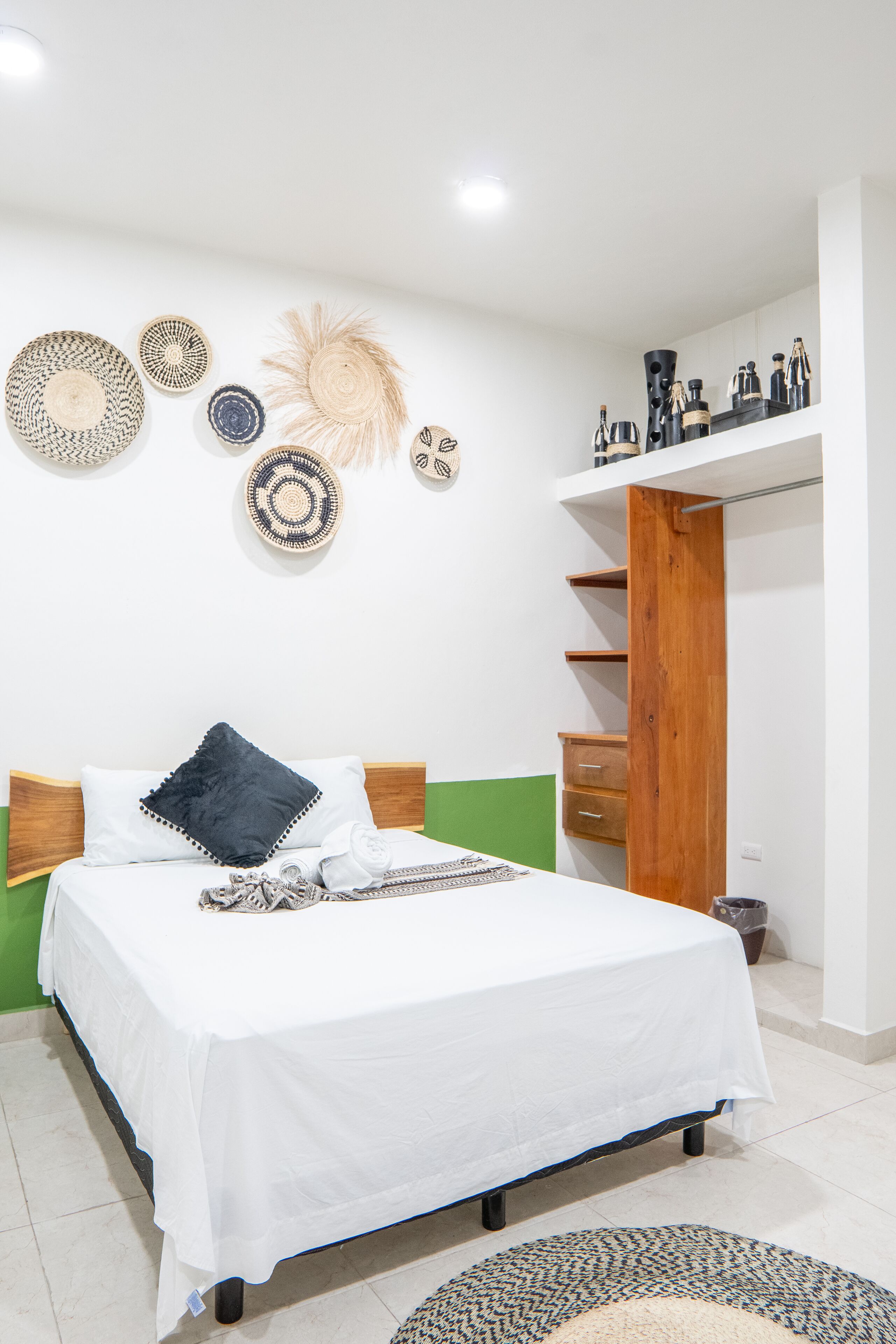 A neatly arranged bedroom with a bed, bedside tables, a wardrobe, and wall decorations.