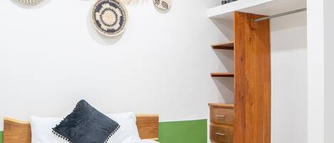 A neatly arranged bedroom with a bed, bedside tables, a wardrobe, and wall decorations.