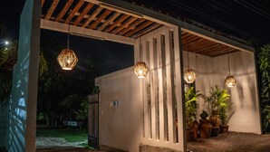 A covered outdoor area with hanging light fixtures and potted plants.