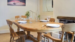 Un coin repas avec une table en bois, des chaises et un tableau accroché au mur.