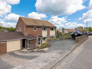 Une rue résidentielle bordée de maisons, avec un garage et des voitures garées.