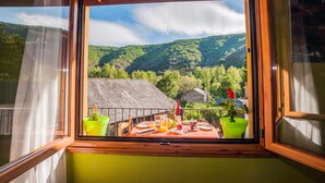 A balcony with a table set for breakfast, overlooking a mountainous landscape. - Rural House With Jacuzzi and Fireplace in the Room for 2 People (Riello)