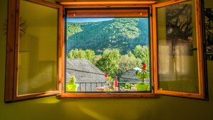 A window with a view of a forested hillside. - Rural House With Jacuzzi and Fireplace in the Room for 2 People (Riello)