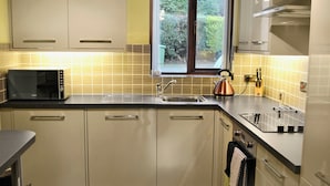 A modern kitchen with a microwave, sink, and kettle. - 2 bedroom accommodation in Bowness on Windermere (Bowness on Windermere)