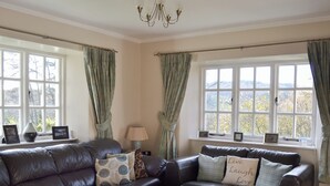 A living room with a dark leather sofa, a wooden coffee table, and a lamp. - 3 bedroom accommodation in Satterthwaite (Satterthwaite)