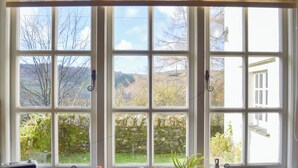 A room with a large window overlooking a landscape, a radiator, and a small table with a radio. - 3 bedroom accommodation in Satterthwaite (Satterthwaite)