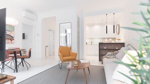 A modern living room with a sofa, a coffee table, and a dining area with chairs. There is a kitchen visible in the background. - CONCHA CITY CENTER, FREE PARKING! Top location. Air Conditioning !  (Donostia)