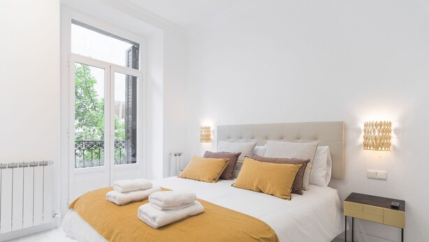 A modern bedroom with a large bed, two bedside tables, and a view of greenery outside. - CONCHA CITY CENTER, FREE PARKING! Top location. Air Conditioning !  (Donostia)