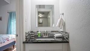 A bathroom with a sink, mirror, and towel rack.