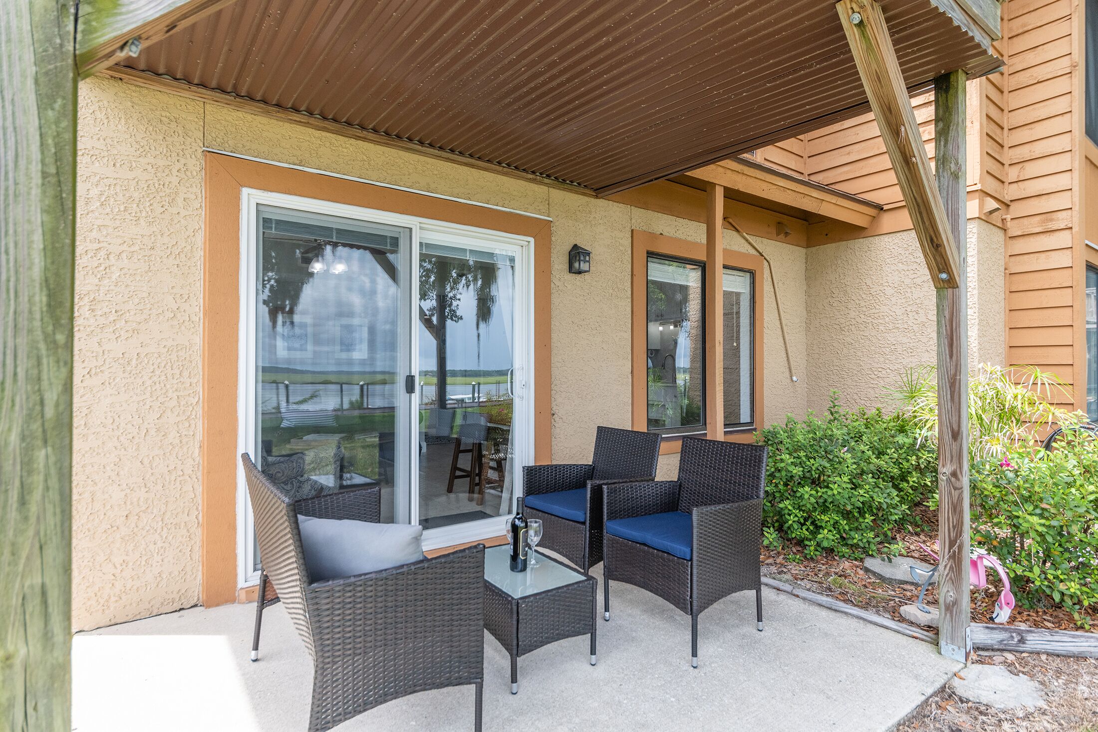 Un patio al aire libre con muebles de mimbre y una mesa de vidrio.