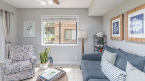 Ein Wohnzimmer mit einer Couch, einem Sessel und einem Deckenventilator.