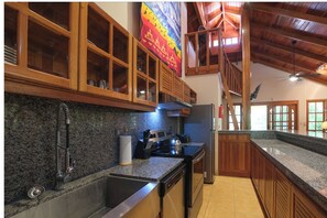 Enjoy cooking in this well-equipped kitchen with a granite countertop, stainless steel appliances, and wooden cabinetry.