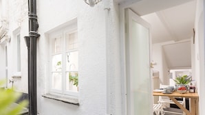 Un bâtiment blanc avec une porte donnant sur une salle à manger.