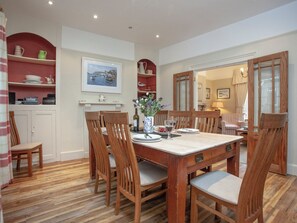 A dining area with a wooden table, chairs, and a painting on the wall. - 4 bedroom accommodation in Cliff Rd/Courtenay (Cliff Rd/Courtenay)
