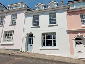 A row of three-story townhouses with white and pink facades, arched doorways, and multiple windows. - 4 bedroom accommodation in Cliff Rd/Courtenay (Cliff Rd/Courtenay)