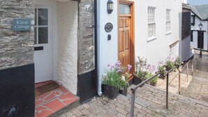A traditional cottage with a stone facade, a wooden door, and a sign reading "Kitcat Cottage". - 2 bedroom accommodation in 6 Horn Hill Steps (6 Horn Hill Steps)