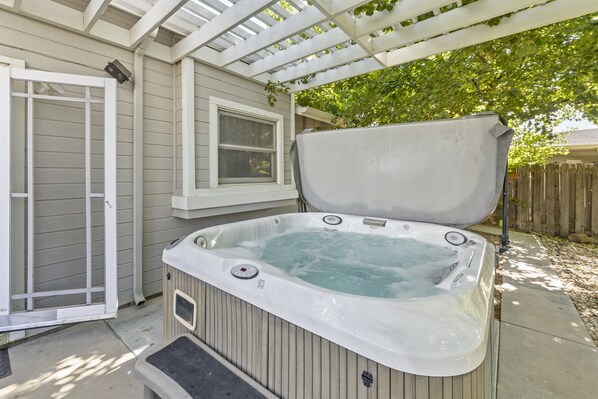 A hot tub in a covered outdoor area with a wooden deck and a window. - Heart of Boise*Simplot sports complex*Pool Table (Boise)