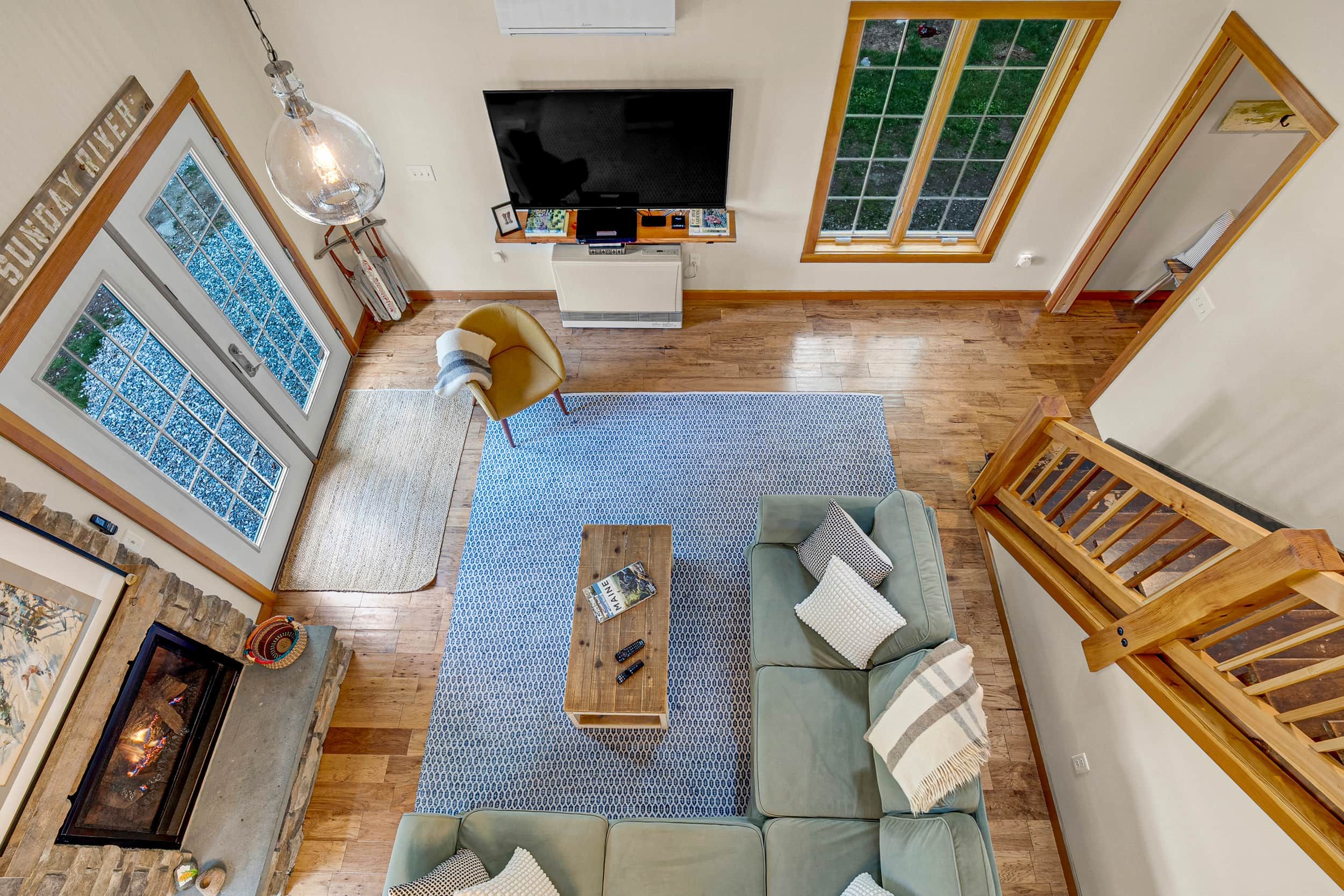 Una sala de estar con televisión, sofá, mesa de centro y chimenea.
