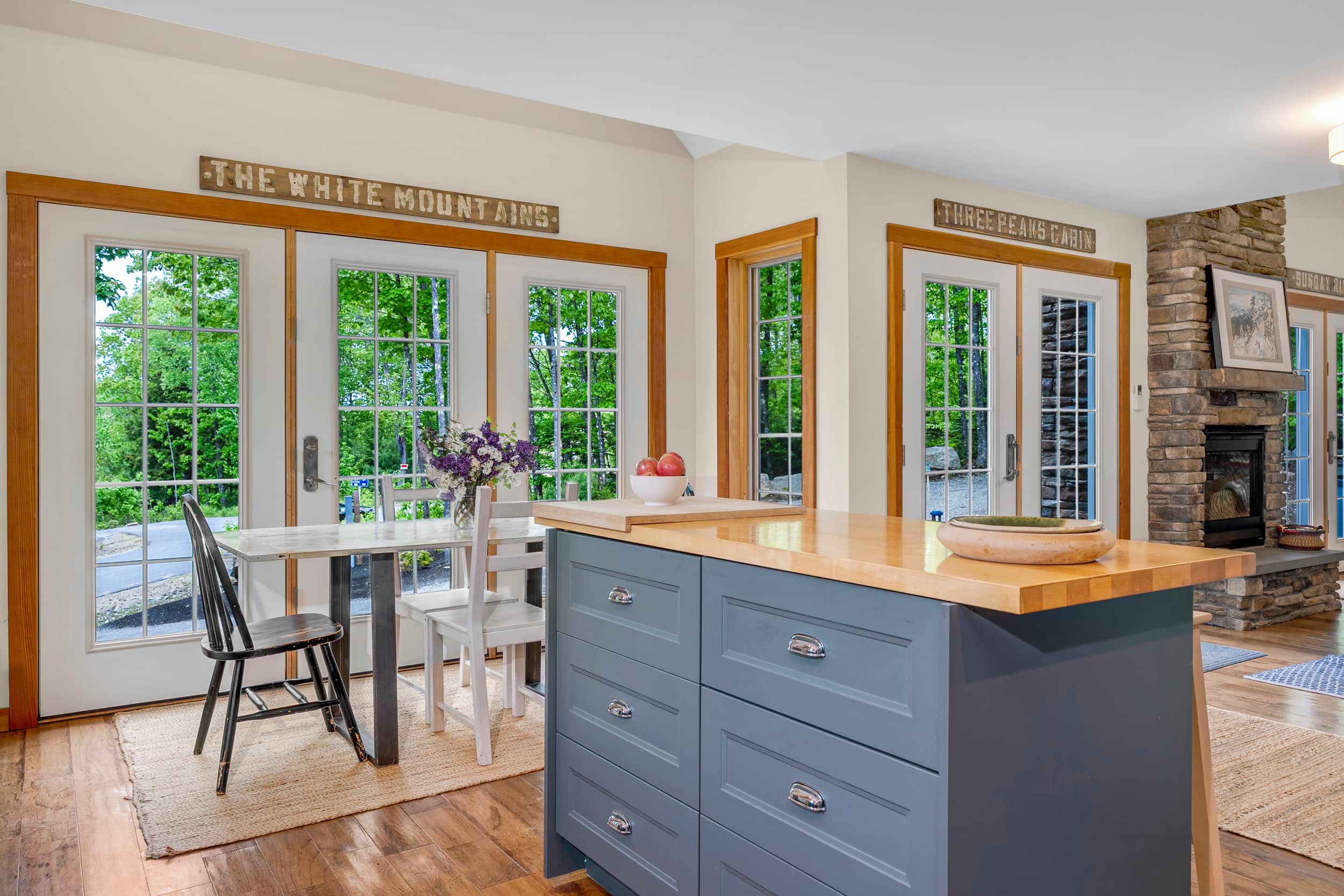 A kitchen with a large island, wooden cabinets, and a stone fireplace.