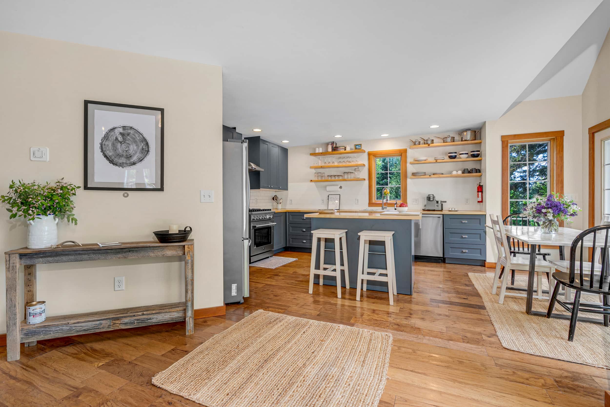 Une cuisine moderne avec un plancher en bois, un îlot central et des étagères intégrées.